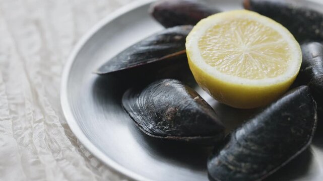 Close-Up of Turkish Stuffed Mussels Served with Lemon on Metal Plate
