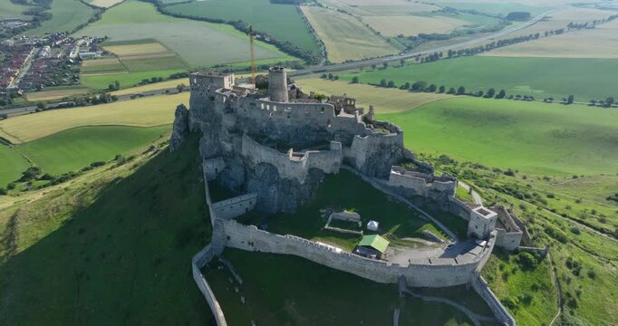 4K Pull out camera movement aerial drone view of the ruins of Spis Castle in eastern Slovakia, the castle is situated above the town of Spisske Podhradie, UNESCO Heritage listed site, Spis, Slovakia