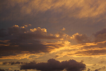 Fototapeta premium Contrasting orange and purple cloud formations, framed horizontally