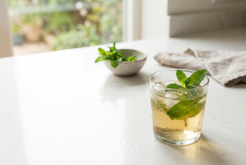 Fototapeta premium Refreshing Iced Tea With Fresh Mint Leaves On White Counter
