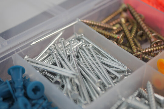 Various types of metal fasteners in a storage box