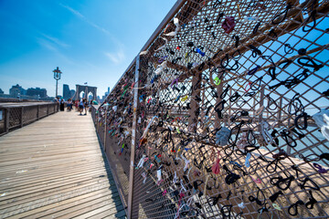 New York City, NY - June 12, 2025: Brooklyn Bridge safety fence covered with colorful padlocks in New York City urban environment