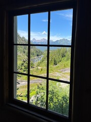 View of Majestic Alpine Mountains and Lake Framed Through a Rustic Wooden Window in the Pacific Northwest
