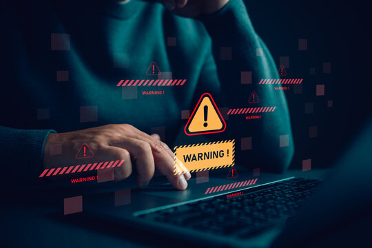 Cybersecurity warning alert with danger symbol over laptop screen, representing system breach risk, malware attack, data protection failure and online threat detection in digital business environment.