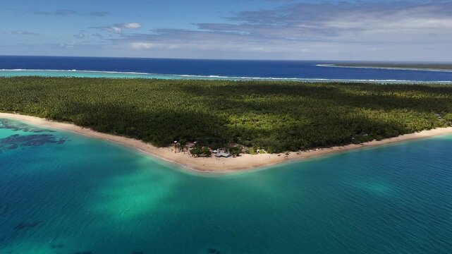 Aerial drone view above the turquoise shoreline of Eua, Kingdom of Tonga, where crystal-clear water reveals coral formations beneath the surface near the untouched tropical coast.