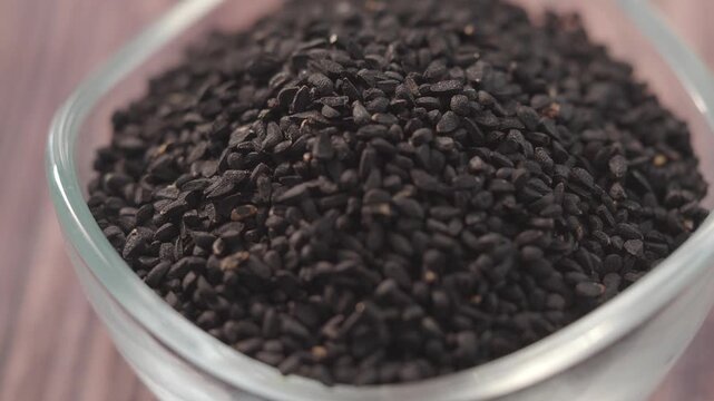 black cumin seeds pouring in a small bowl 