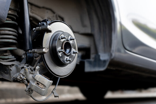 Car brake system maintenance concept, Close up the rear brake disc and calliper, Replacing worn disc rotor with new part for vehicle safety, Automotive repair service and professional inspection