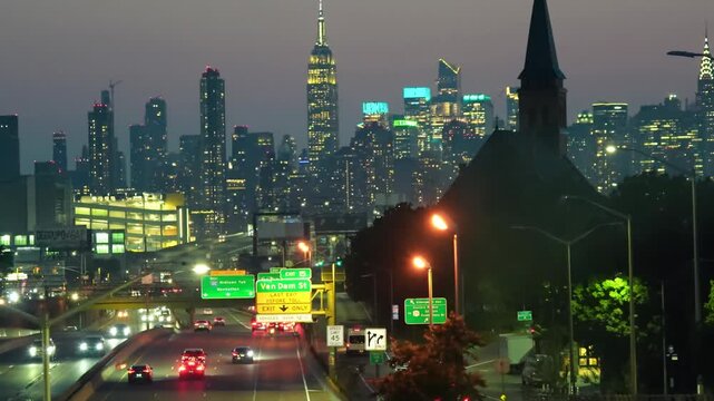 Aerial night view of a highway approaching New York City and its illuminated towers