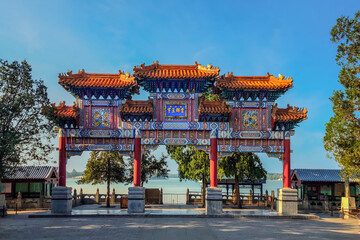 Obraz premium Ornate Chinese Traditional Archway Gate at Yiheyuan Summer Palace Beijing with Lake View and Blue Sky