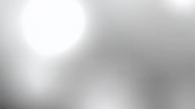 Soft blurred grayscale light glows near top-left corner, creating a minimalist gradient background in a dreamy photographic view