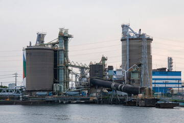 Obraz premium Large Concrete Silos and Industrial Facility by the Waterfront