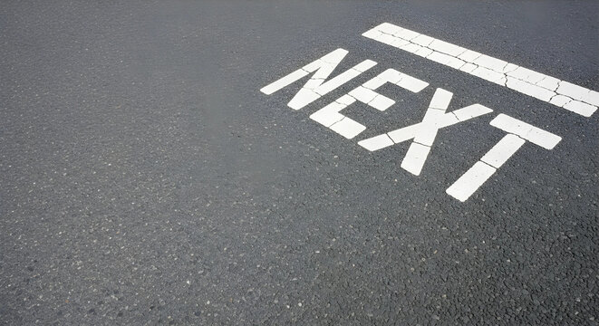 右上の停止線とNEXTの文字。左側と下部に広い余白があるアスファルト道路背景。ビジネスの開始。