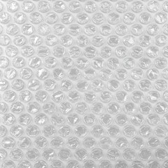 無数の透明な気泡が規則的に並んだ、光沢のあるバブルラップのクローズアップテクスチャ背景。梱包材や保護材のイメージ、または抽象的なパターンとして利用可能。