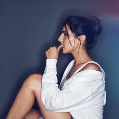Fototapeta premium Thinking, biting nails and profile of woman in studio for reflection, thoughtful and nervous with style. Dark background, shirt and person with memory, daydreaming and wondering in casual clothes