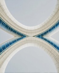Obraz premium Modern futuristic architecture with curved glass facade and white panels creating a symmetrical geometric pattern for commercial corporate backgrounds with copy space