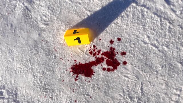 Slight overhead spin reveals numbered marker beside red stain crystallizing on compacted snow under bright sun.