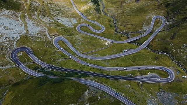 High-altitude drone pullback revealing winding mountain switchbacks below