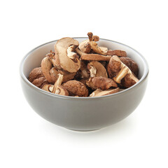Bowl with dried mushrooms isolated on white background, closeup