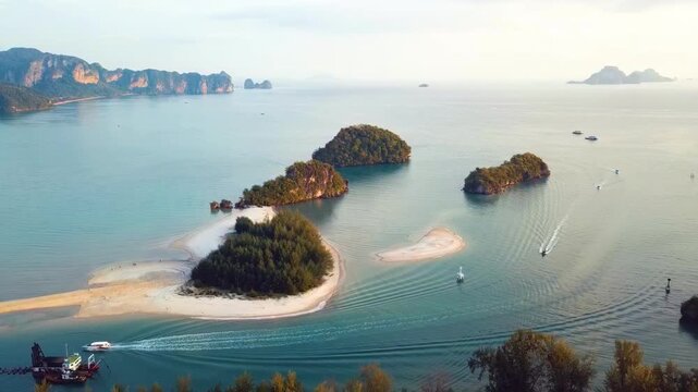 Stunning aerial perspective of Nopparat Thara beach featuring turquoise waters, tropical limestone islands, and longtail boats cruising in the Andaman Sea. Perfect for travel and vacation content.