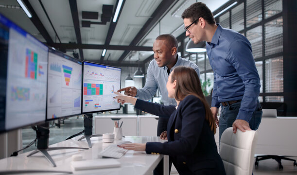 Celebrating With Colleagues As Woman Monitors KPI Traffic Spike On Dashboard