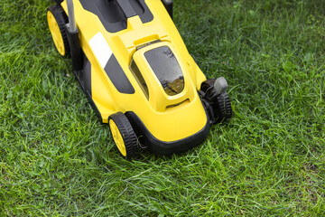 Modern lawn mower on green grass outdoors