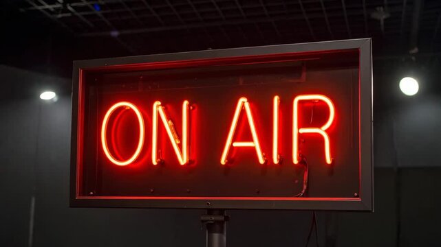 Bright red neon "ON AIR" sign illuminates a dark studio with atmospheric lighting