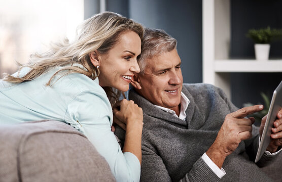 Love, couple and talking with tablet on sofa for online shopping, app choice and marriage support. Pointing, mature people and relax with tech in home for browsing, purchase decision and relationship