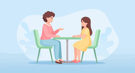 Two people seated at a table having a conversation