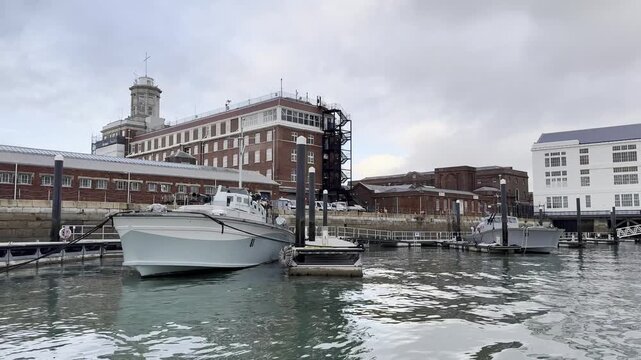 Scenic view of South Camber&rsquo;s harbor, featuring boats, docks, and historic red-brick buildings.