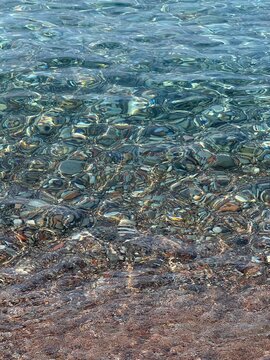 Sea clear water with pebbles vertical.