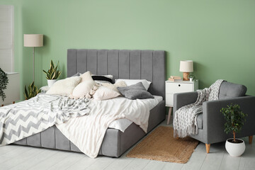 Modern bedroom with bed, bedside tables, armchair and lamp