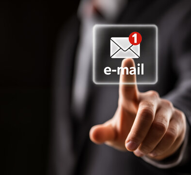 A businessman's hand presses the email notification icon with the word e-mail on a digital interface, representing online messaging, corporate communication, and modern technology concept.