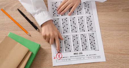 Schoolboy with results of test on table, top view