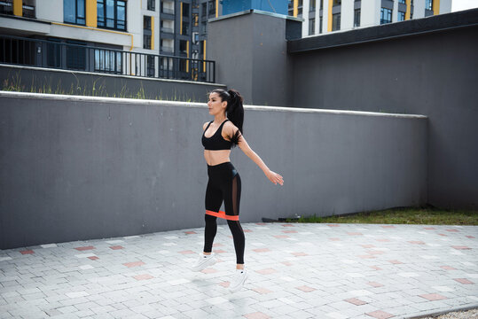 Fitness brunette woman in black leggings training outdoor