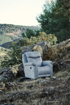 Modern armchair placed in rugged rocky landscape outdoors