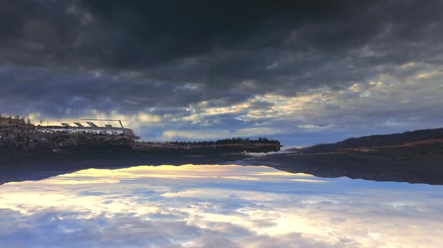Crystal clear lake reflection filmed upside down creating surreal mirrored sky and mountain panorama