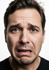 Fototapeta premium Emotional Portrait Of Man With Fearful Expression And Tear Running Down Face Against White Background