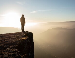 a silhouetted hiker standing on a dramatic mountain cliff at sunset, looking out over a vast valley and distant peaks under a vibrant golden sky