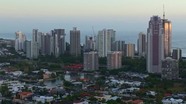 Aerial drone footage panning left over the Nerang River from Budds Beach, passing high-rise apartments with the Gold Coast beach in the background.