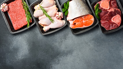Raw fresh meat and fish in Black plastic packaging trays from supermarket. Top view. Food...
