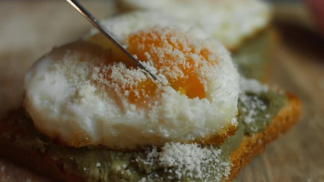 Egg yolk on a toasted slice of bread being cut open