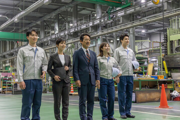 Obraz premium 工場で並んで立つ作業スタッフのグループ