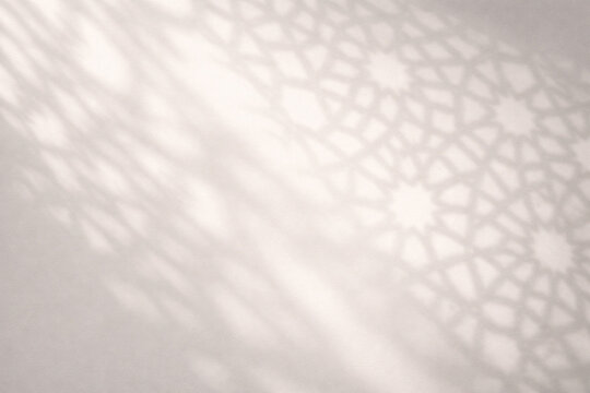Geometric shadow patterns on a light wall, creating an abstract and serene background.