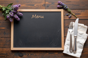 Blank chalkboard menu mockup on dark wood table with lavender and utensils.