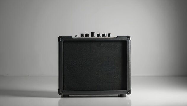 Black guitar amplifier sits on white studio floor. Small combo amp has speaker grille and top controls. Object is isolated, perfect for music or tech graphics.