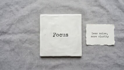 Square tile with the word Focus on a textured surface