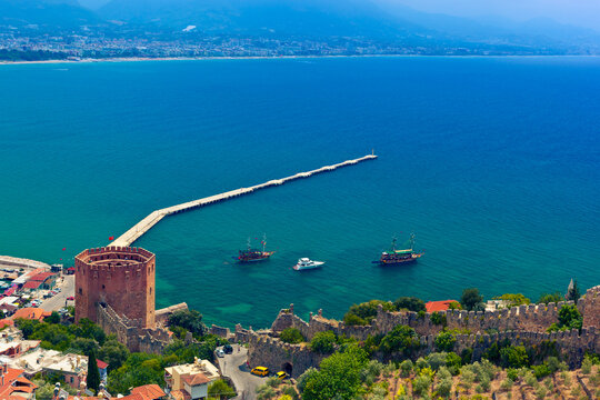 View of Alanya harbor, Red Tower and stone wall of Alanya Castle. Alanya, Turkey