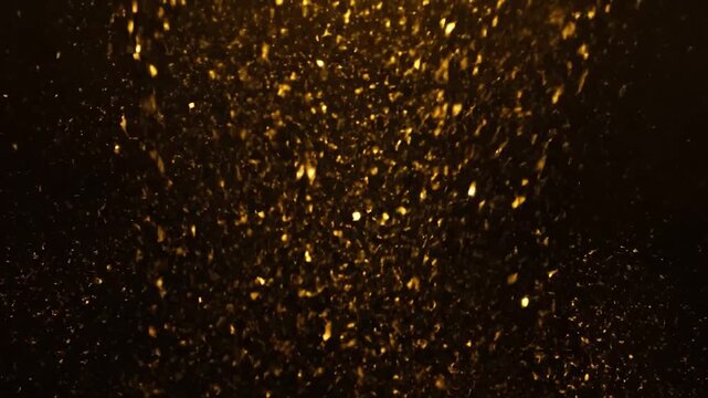Abstract golden particles seemingly floating against a dark background, creating a mesmerizing effect