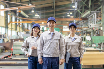 工場の中に立つ作業員グループ