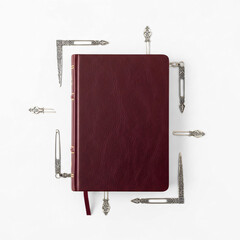 Elegant burgundy leather book surrounded by antique silver bookmarks on white